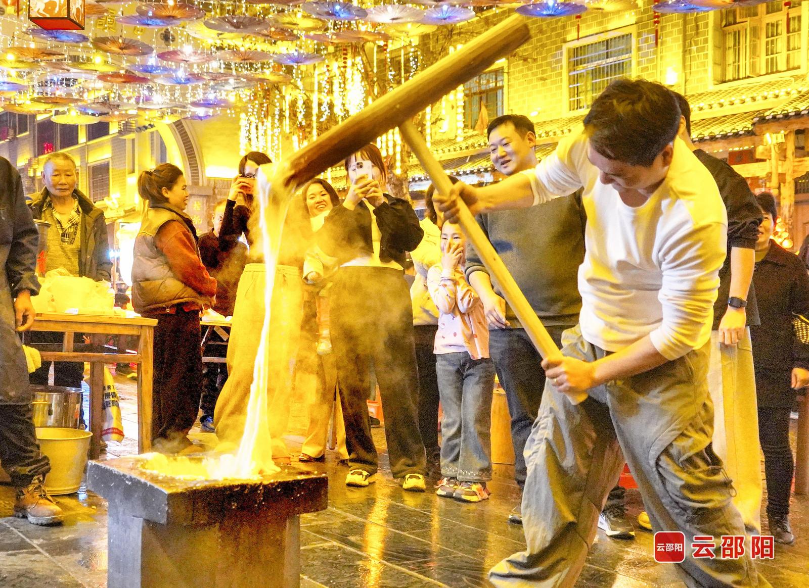 2月21日,武冈市西直街烟火气拉满,打糍粑的热闹场景吸引众多市民观看,沉浸式感受浓郁的传统年味。 罗红英 杨运焰 摄影报道